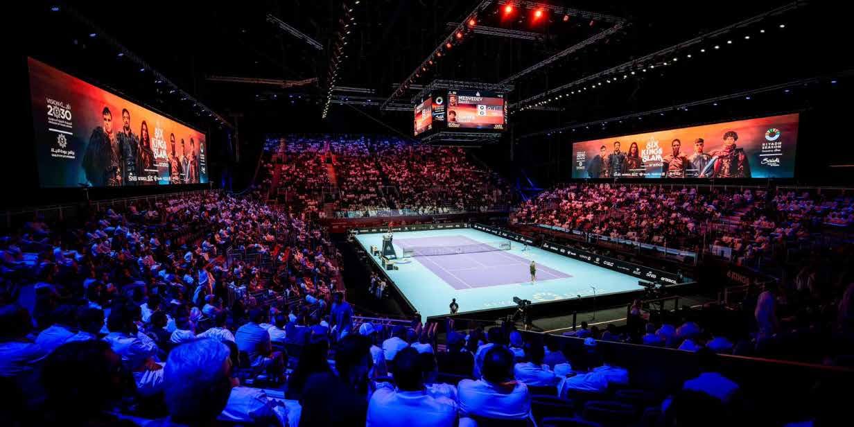 Six Kings Slam arena in Riyadh during a match, full stands around the court